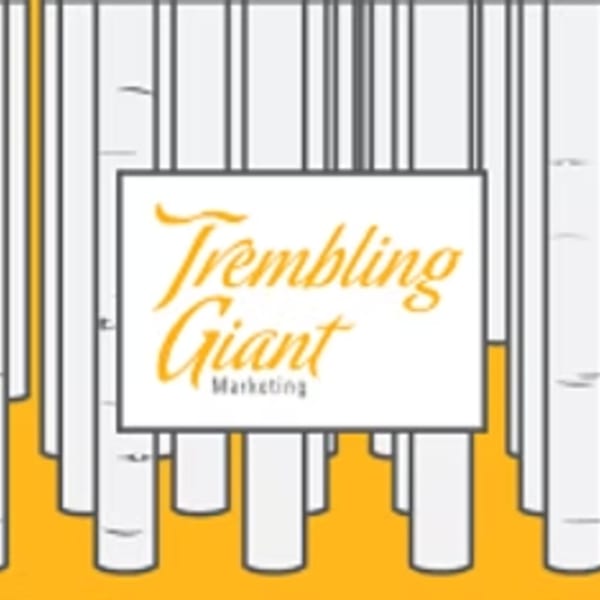A white sign with "Trembling Giant Marketing" in orange script, surrounded by white tree trunks.